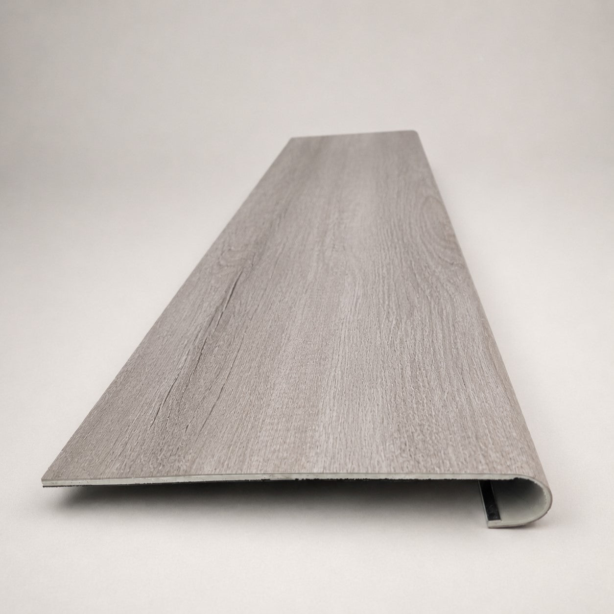 Custom round-nose stair tread made from Style Selections Charleston Oak flooring. Round profile. Front view.
