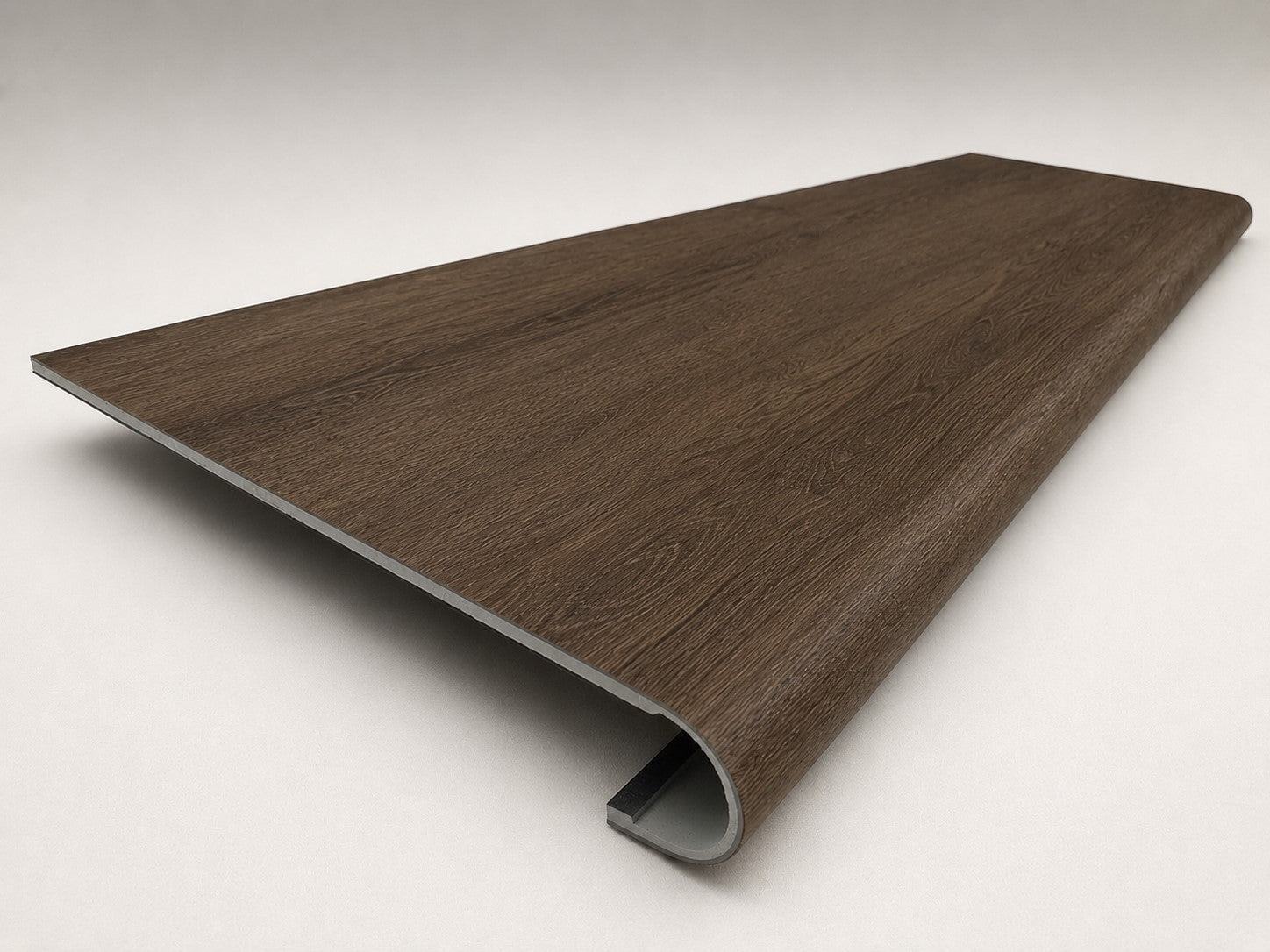 Custom round-nose stair tread made from Style Selections Tudor Oak flooring. Round profile. Angled view.