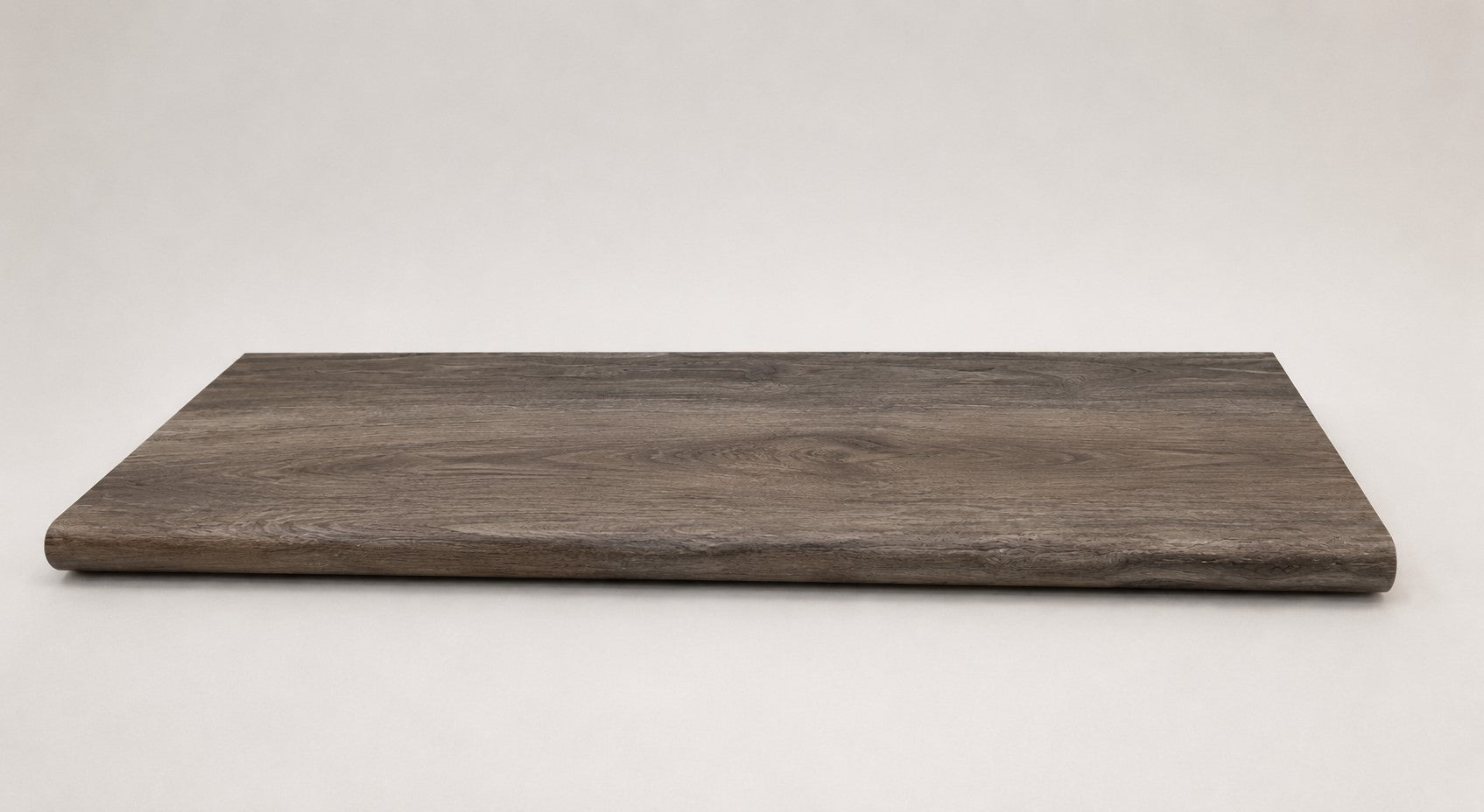 Custom round-nose stair tread made from DuraLux Performance Stormy Elm flooring. Round profile. Full view.